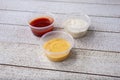 three plastic condiment cups, ranch, honey mustard, BBQ sauce