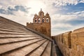 Tiled slanted roof of the fortified church Notre-Dame-de-la-Mer with blue cloudy sky, Saintes-Maries-de-la-Mer, Camargue, France