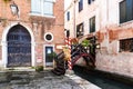 View of tiny bridge with flowers and lampposts into a typical Venice restaurant