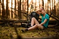 View of tired young woman in forest who is sitting near fallen tree Royalty Free Stock Photo