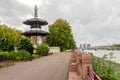 A view to the alley along Thames river in Battersea park with London Peace Buddhist Pagoda and Albert Bridge, London, England