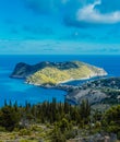 View to Assos village and beautiful blue sea. Cypress trees in foreground. Kefalonia island, Greece