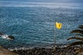 View to Atlantic Ocean and yellow flag on the Callao Salvaje beach.