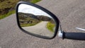 A view to blurred old motorbike mirror with a road in reflextion somewhere in Scotland Royalty Free Stock Photo