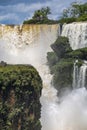 Close-up view of powerful cascading waterfalls and lush green vegetation and blue sky, Iguazu Falls, Argentina