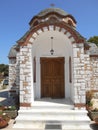 View to door of white and brown church of Agios Nikolaos and Agia Anastasia at the fishing harbour of Olympiada, Halkidiki