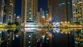 View to Dubai Marina skyscrapers from Jumeirah Lakes Towers. Beautiful illumination of buildings with colorful lights.