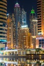 View to Dubai Marina skyscrapers from Jumeirah Lakes Towers. Beautiful illumination of buildings with colorful lights.