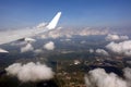 View to the earth from passenger supersonic airplane window flying high in the sky above white clouds