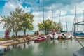 View to entrance to Siofok harbor at Balaton lake, Hungary, with crystal clear water of emerald color, green coastline, puffy