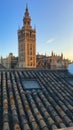 View to the Giralda, the bell tower of Seville Cathedral. Tile roof with the windows in the foreground Royalty Free Stock Photo