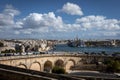 View to Grand Harbour in Valletta, Malta. Road viaduct in foreground, ships moored at the docks.