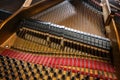 View to hammer and damper on the strings inside an older grand piano, part of the mechanics in the acoustic musical instrument