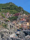 View to Manarola city, one of the towns of Cinque Terre five lands protected by UNESCO. Colorful houses and green hills