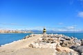 A view to Mediterranean sea, a lighthouse with breakwaters, fishing rods of locals and Torremolinos at the background Royalty Free Stock Photo