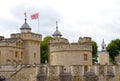 View to parts of the tower of london with the Union Jack from the land side at a cloudy day