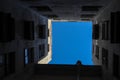 View to the piece of blue sky from the bottom of the dark well yard in Saint Petersburg, Russia