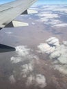 View to the plain wing clouds earth sea mountains from the airplane window