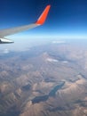 View to the plain wing clouds earth sea mountains from the airplane window