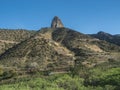 View to the Roque Cano, a famous volcanic cliff on the north side of La Gomera. Rural mountain landscape with terraced