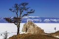 View to the Shamanka rock and a wishing tree on cape Burhan of Olkhon island on lake Baikal. Irkutsk region Royalty Free Stock Photo