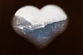 View to snowy Swiss alps in winter through wooden heart shape Royalty Free Stock Photo