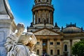 A statue of the Schiller monument and the unfocussed German Cathedral in the background Royalty Free Stock Photo
