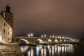 View to the stone bridge in Regensburg at night in the fog over the river Danube with the illuminated cathedral and historical old Royalty Free Stock Photo