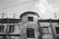 View to the top floor of an old, flaky house with a circular entrance and roof antennas. Black and white photo Royalty Free Stock Photo