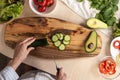 The view from the top as a white woman cut pieces of ripe cucumber salad Royalty Free Stock Photo