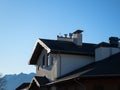 View of the top fragment of the house on a background of mountains and blue sky