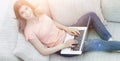 Girl student working with laptop sitting on sofa and looking at Royalty Free Stock Photo