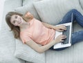 Girl student working with laptop sitting on sofa and looking at camera. Royalty Free Stock Photo