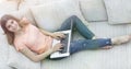 Girl student working with laptop sitting on sofa and looking at camera. Royalty Free Stock Photo