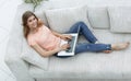 Girl student working with laptop sitting on sofa and looking at camera. Royalty Free Stock Photo