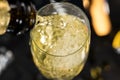 View from top glass of sparkling champagne with bubbles and foam. Close up pouring white wine from bottle into glass Royalty Free Stock Photo