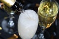 View from top glass of sparkling champagne with bubbles and foam. Close up pouring white wine from bottle into glass Royalty Free Stock Photo