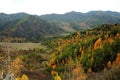 The view from the top of the mountain to the autumn landscape of the valley and the loop of the old road going through the forest Royalty Free Stock Photo