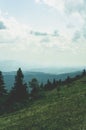 View from top mountain to wooded mountain landscape against background sky covered white-gray dense clouds. Royalty Free Stock Photo