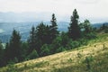 View from top mountain to wooded mountain landscape against background sky covered white-gray dense clouds. Royalty Free Stock Photo