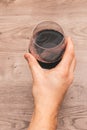 View from the top of one hand holding a glass filled with red wine Royalty Free Stock Photo