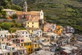 View at top part of Vernazza village With San Francesco Church. Hill slope with vineyards is at background. Cinque Terre coastal