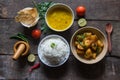 View from top of simple Indian food or meal with potato fry, rice, lentils, papad and condiments.