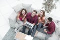 Triumphant group of friends laughing while sitting on the couch in the living room Royalty Free Stock Photo