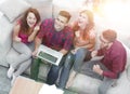 Triumphant group of friends laughing while sitting on the couch in the living room Royalty Free Stock Photo