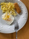 View from top of white plate with chips and egg meal Royalty Free Stock Photo