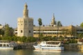 View of the tour boats and octagonal tower of Torre del Oro makes golden reflection on Canal de Alfonso of Rio Guadalquivir