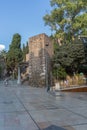 View at the tourist people visiting and strolling on Malaga Alcazaba building entrance, fortress and pedestrian path crossing with