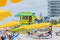 View of tourists on colorful sunbeds next to a lifeguard tower on Miami Beach in a sunny summer day. Royalty Free Stock Photo