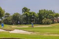 View of tourists playing golf on sunny summer day.